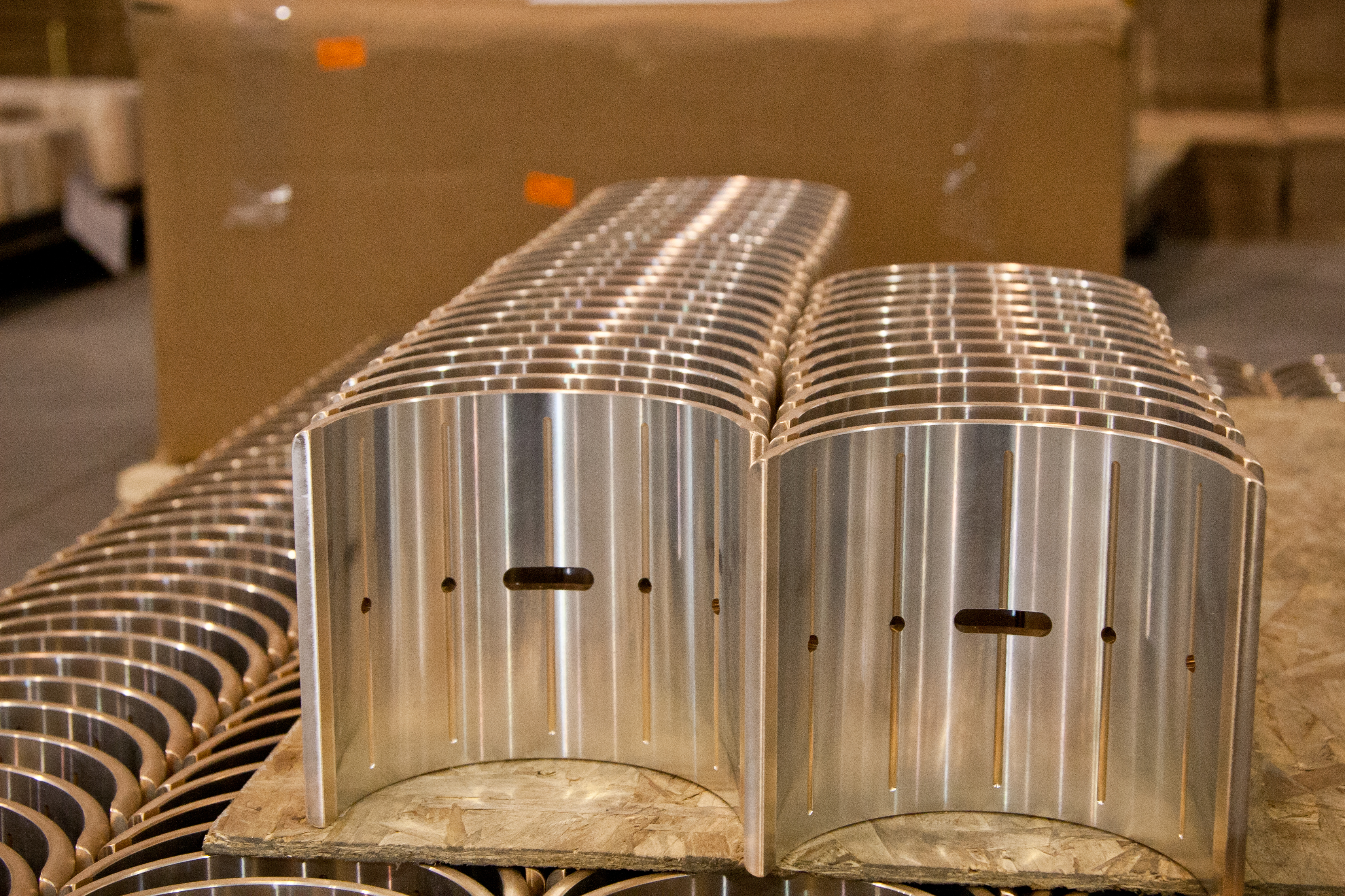 Stacked semi-cylindrical bearing shells with oil grooves and drilled holes, ready for assembly or finishing.