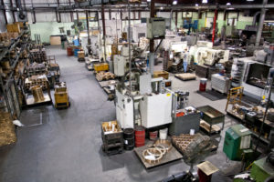 Wide view of Magnolia Metal’s machine shop floor with CNC machines and metal parts staged for production.